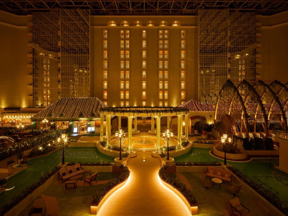 Grand Nikko Tokyo Bay Maihama Hotel Urayasu Eksteriør billede The photo shows a beautifully illuminated indoor space resembling a luxury hotel or resort. There are elegant architectural features, including large columns, arches, and decorative lighting. The area is designed with lush greenery and well-maintaine
