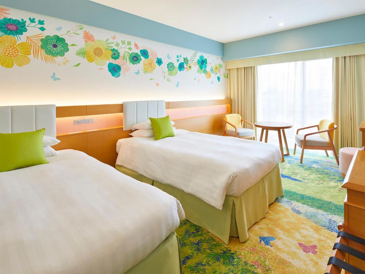 Grand Nikko Tokyo Bay Maihama Hotel Urayasu Eksteriør billede The photo shows a brightly decorated hotel room featuring two twin beds with white linens and light green accents. Above the beds is a colorful floral mural that adds a cheerful touch to the space. There is a small table and chairs by the window, whi