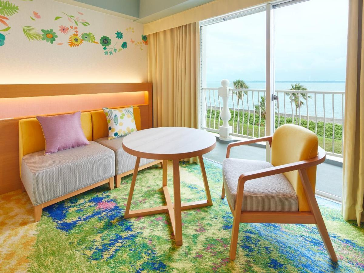 Grand Nikko Tokyo Bay Maihama Hotel Urayasu Eksteriør billede The photo shows a cozy interior space, likely a hotel room or a lounge area. It features a small round table in the center surrounded by comfortable seating. There are two chairs: one is a light wooden frame with a yellow seat, and the other has a mo
