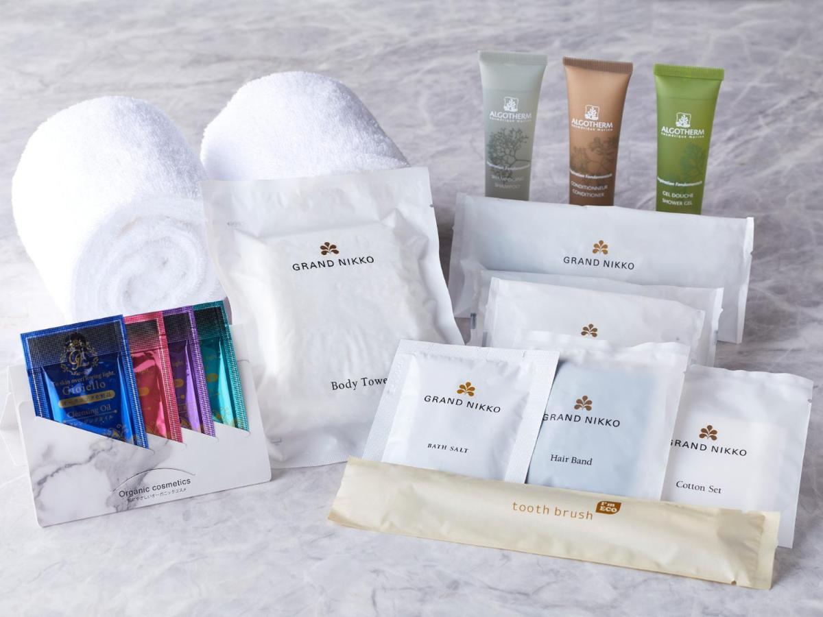 Grand Nikko Tokyo Bay Maihama Hotel Urayasu Eksteriør billede The photo displays a collection of spa or hotel toiletries. It includes:

- Two fluffy white towels.
- Multiple packages labeled "GRAND NAKO," which appear to be spa or body care products.
- Several small tubes of hair and body care items in green an