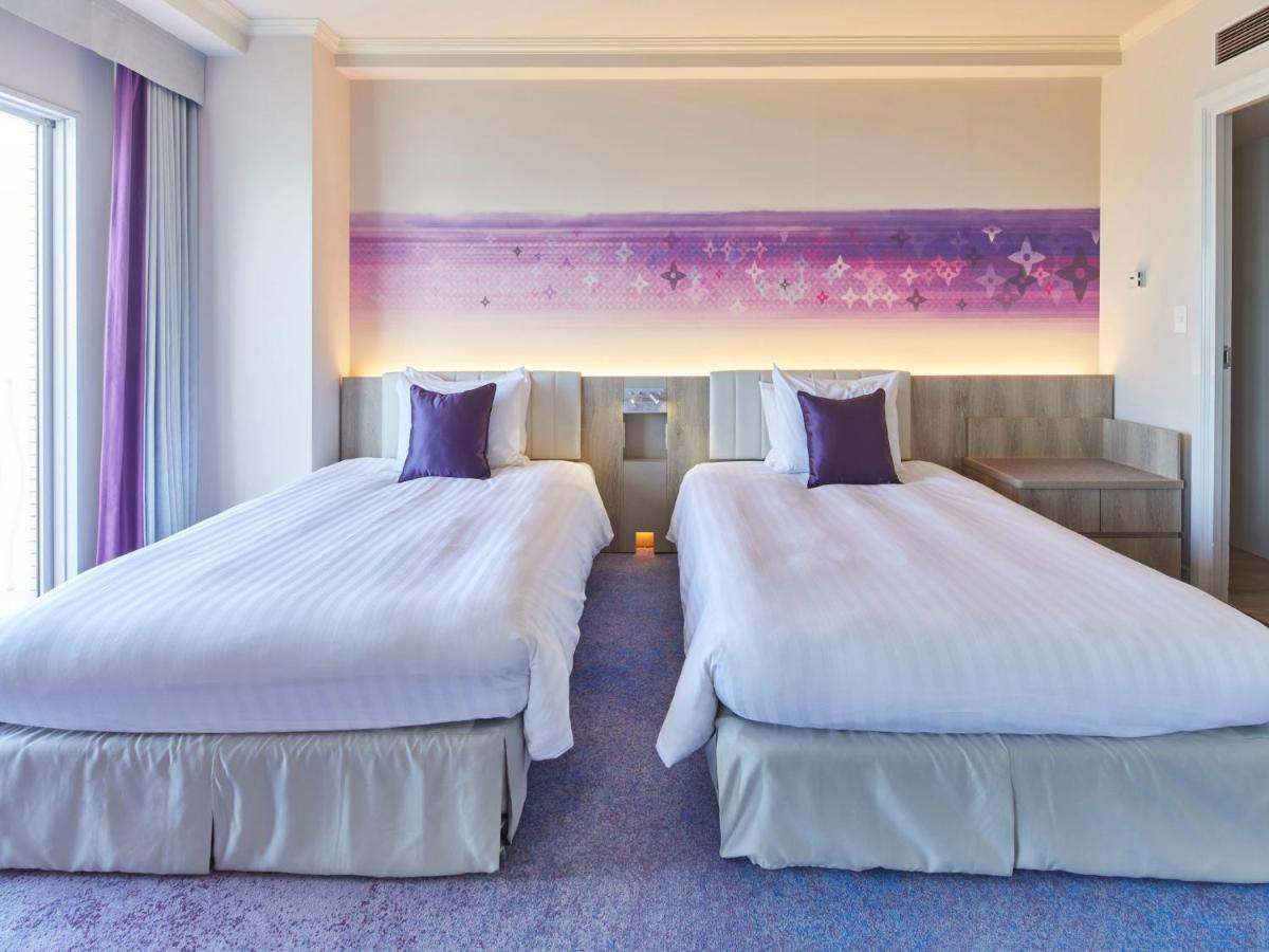 Grand Nikko Tokyo Bay Maihama Hotel Urayasu Eksteriør billede The photo shows a hotel room featuring two twin beds with white bedding and purple accent pillows. The beds are positioned next to each other, with a light-colored headboard. Behind the beds, there is a decorative wall with a gradient of purple hues.