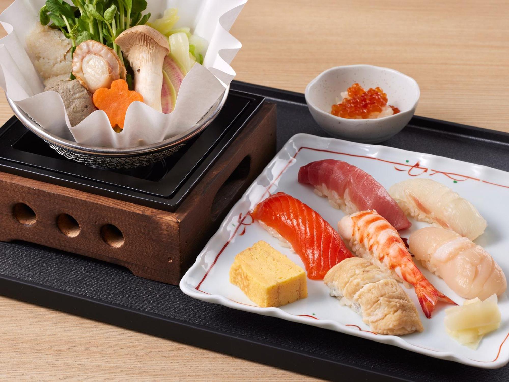 Grand Nikko Tokyo Bay Maihama Hotel Urayasu Eksteriør billede The photo features a Japanese meal presented on a wooden tray. On the left, there is a small pot with a clear broth containing vegetables, mushrooms, and possibly meat, indicated by green herbs and a piece shaped like a flower. On the right, there is