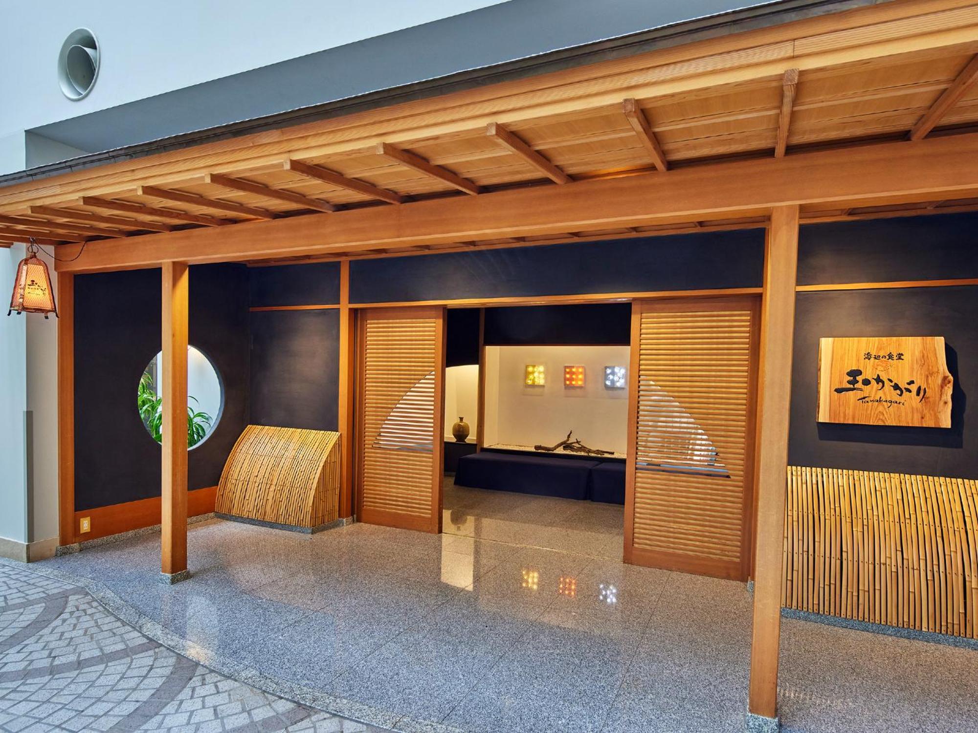 Grand Nikko Tokyo Bay Maihama Hotel Urayasu Eksteriør billede The photo shows the entrance of a building, designed in a traditional Japanese style. It features a wooden structure with a large overhanging roof and sliding doors. The entrance is flanked by rounded windows, and there's a decorative sign with Japan
