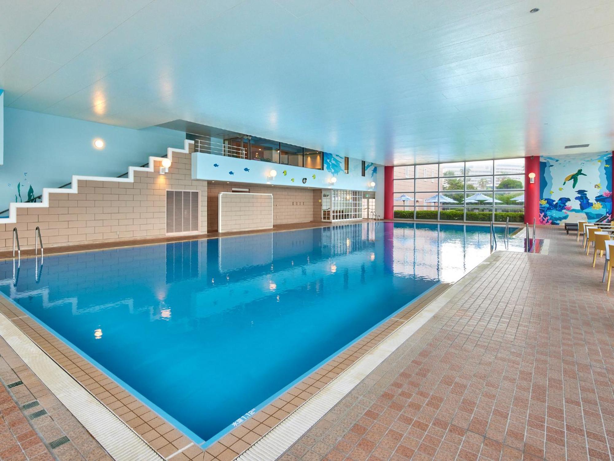 Grand Nikko Tokyo Bay Maihama Hotel Urayasu Eksteriør billede The photo shows an indoor swimming pool area with a spacious design. The pool has a clear blue water surface and is surrounded by a tiled deck. On one side of the pool, there are steps leading into the water, and there are large windows letting in na